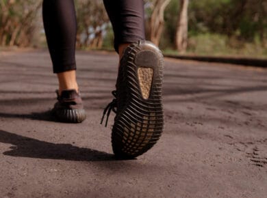 Άτομο που περπατά με σωστή στάση σώματος σε εξωτερικό χώρο, αναδεικνύοντας την ευθυγράμμιση και την ισορροπία.